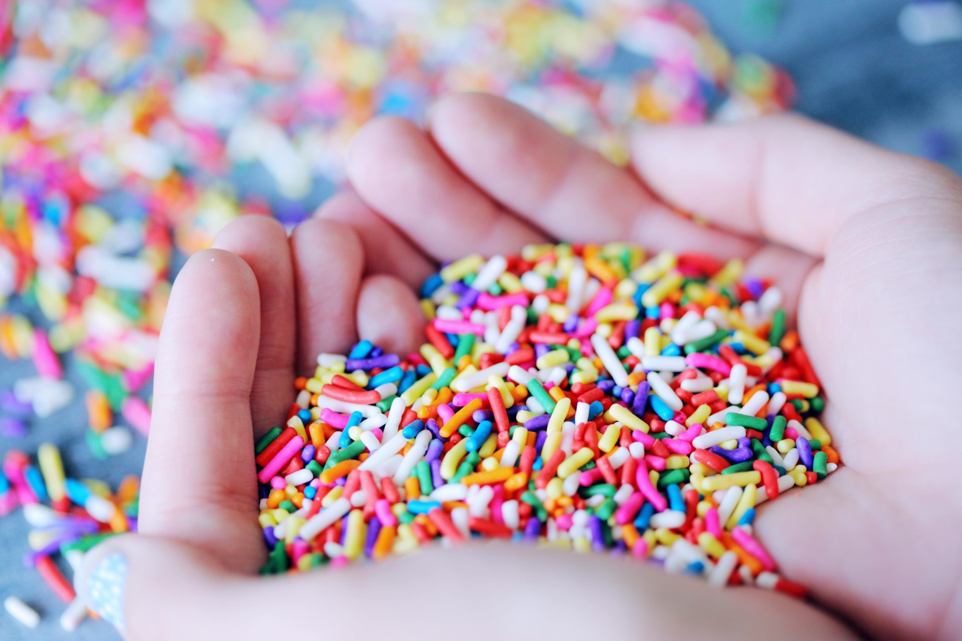 Two hands filled with colourful 100s and 1000s, almost shaped into a heart