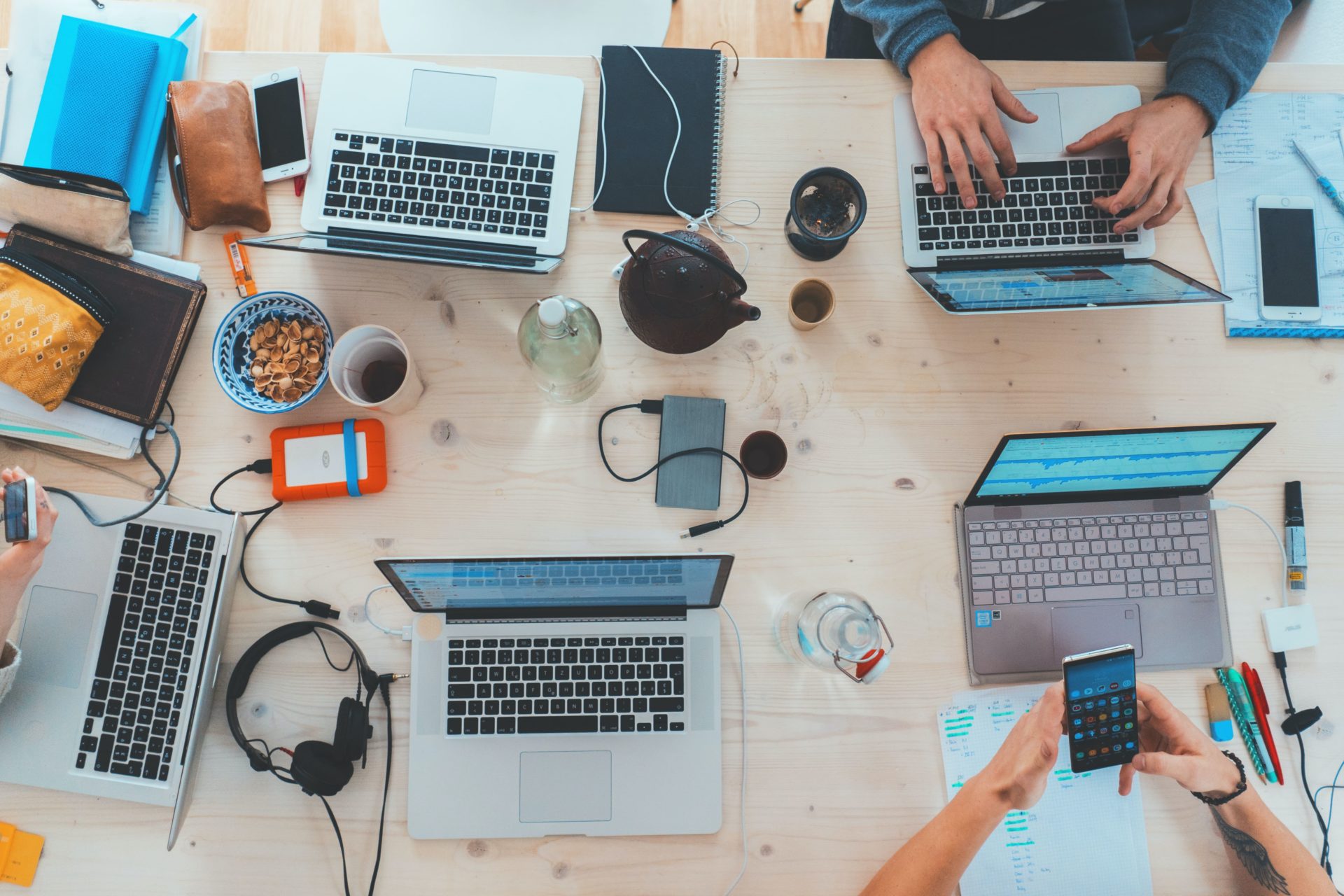 A busy work desk with people using laptops